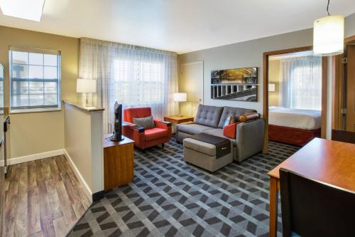 リボニアにあるTownePlace Suites by Marriott Detroit Livoniaのソファとベッド付きのホテルルーム