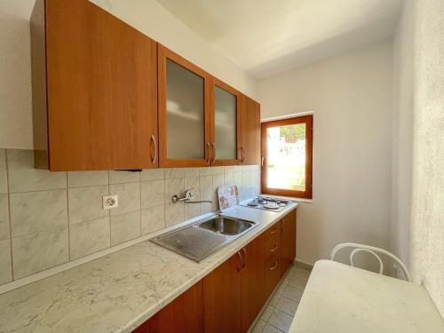 a kitchen with wooden cabinets and a sink at Apartments Marija Magdalena in Hvar