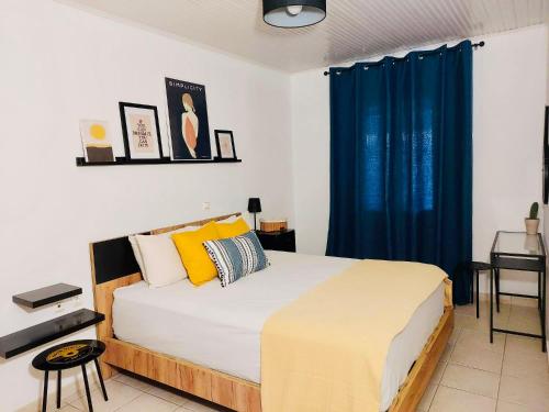 卡拉馬基的住宿－JAVA GEVA zen living，一间卧室配有一张带蓝色窗帘的大床