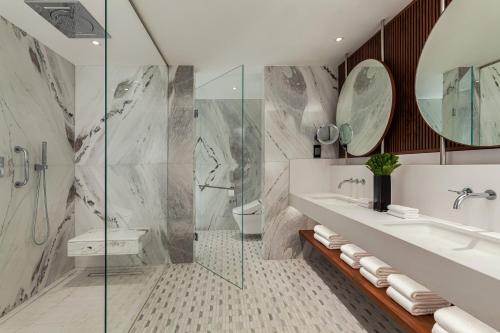 a bathroom with a sink and a shower at Malta Marriott Resort & Spa in St. Julianʼs