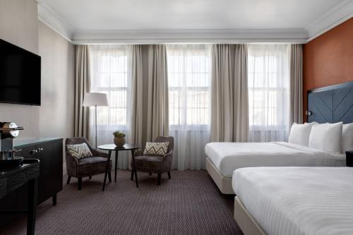 a hotel room with two beds and a table and chairs at Bristol Marriott Royal Hotel in Bristol