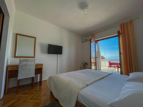a bedroom with a bed and a desk and a window at Apartments Marija Magdalena in Hvar