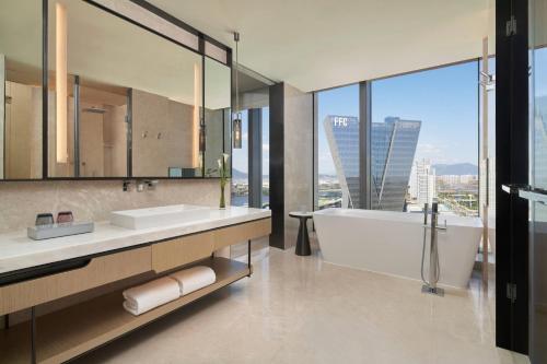 a bathroom with a tub and a sink and mirror at Fuzhou Marriott Hotel Riverside in Fuzhou
