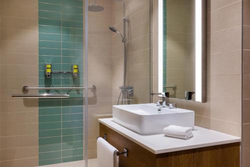 een badkamer met een wastafel en een glazen douche bij Element Al Mina, Dubai Jumeirah in Dubai