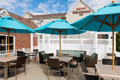 a patio with tables and chairs with blue umbrellas at Residence Inn Appleton in Appleton
