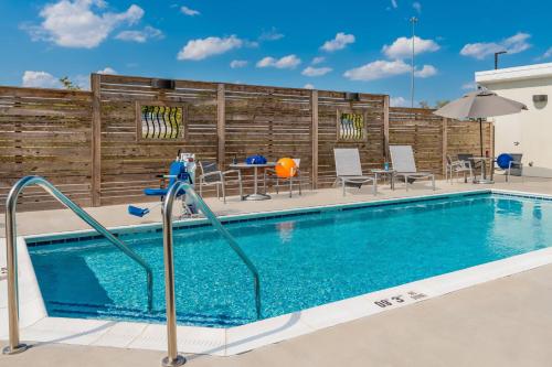 a swimming pool at a hotel with a table and chairs at TownePlace Suites by Marriott Hopkinsville in Hopkinsville