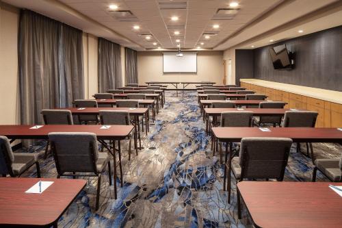 a conference room with tables and chairs and a screen at Fairfield Inn & Suites Seneca Clemson Univ Area in Seneca