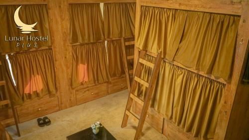 una habitación con cortinas y una escalera en una cabaña en Lunar Hostel Plus en Dubái