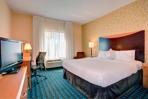 a hotel room with a large bed and a flat screen tv at Fairfield Inn & Suites Cartersville in Cartersville