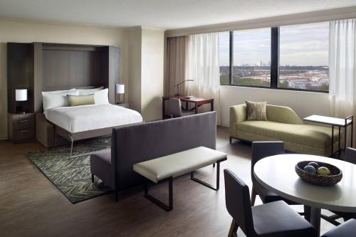 um quarto de hotel com uma cama e uma sala de estar em Atlanta Airport Marriott em Atlanta