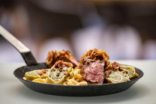 a plate of food with meat and pasta on a table at Stuttgart Marriott Hotel Sindelfingen in Sindelfingen