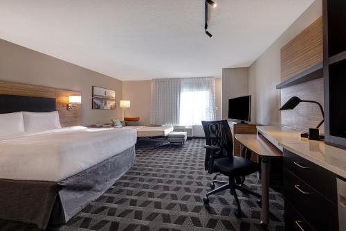 モンローにあるTownePlace Suites by Marriott Monroeの大きなベッドとデスクが備わるホテルルームです。