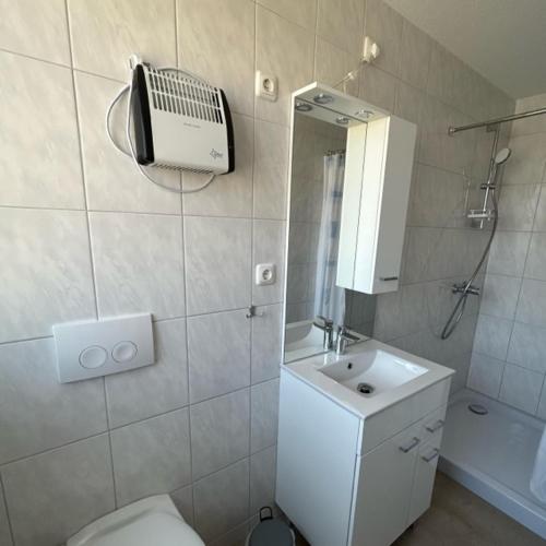 uma casa de banho com um WC, um lavatório e um espelho. em Ferienpark Buntspecht Apartment A em Pruchten