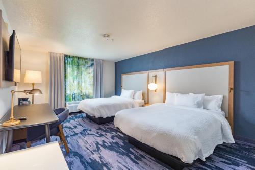 a hotel room with two beds and a desk at Fairfield Inn and Suites by Marriott Tampa North in Tampa