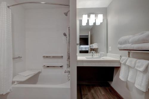 TownePlace Suites by Marriott Monroe في مونرو: حمام مع حوض ومغسلة ودش
