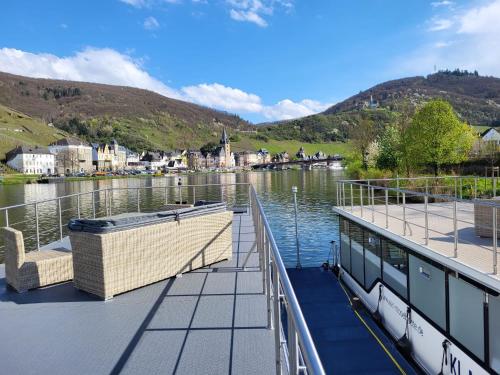 a boat on the water with a town in the background at KL Moselboote - Hausboot Yara in Bernkastel-Kues