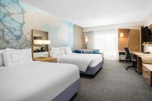 a hotel room with two beds and a desk at Courtyard El Paso Airport in El Paso