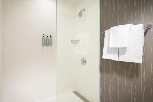 a bathroom with a shower with white towels at Courtyard El Paso Airport in El Paso