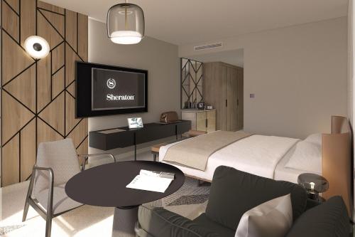 梅里尼亞克的住宿－Sheraton Bordeaux Airport，一间卧室配有一张床、一张桌子和一台电视。