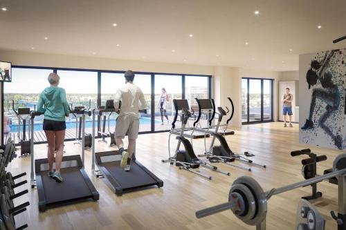 un groupe de personnes faisant de l'exercice sur des tapis de course dans une salle de sport dans l'établissement Sheraton Bordeaux Airport, à Mérignac