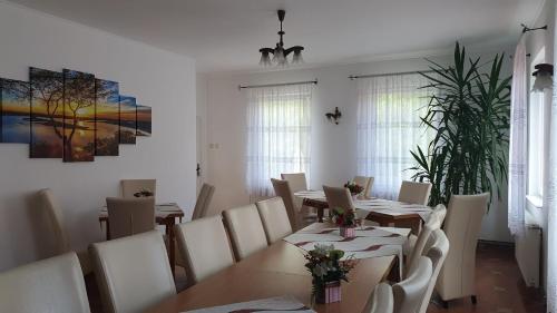 a dining room with wooden tables and white chairs at Pensiunea Paula in Moieciu de Sus