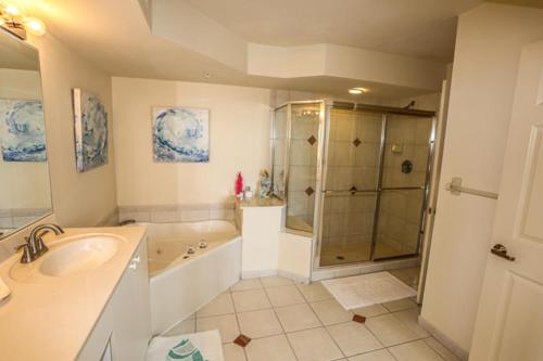 ein Badezimmer mit einer Dusche, einem Waschbecken und einer Badewanne in der Unterkunft Lovers Key Resort 308 in Fort Myers Beach