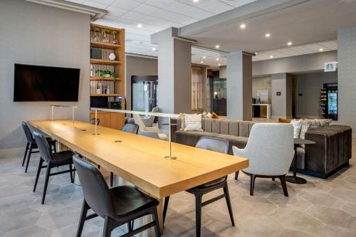 a conference room with a large wooden table and chairs at Sheraton Suites Wilmington Downtown in Wilmington