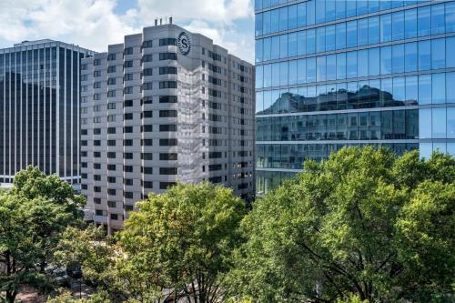 um grupo de edifícios altos em frente às árvores em Sheraton Suites Wilmington Downtown em Wilmington