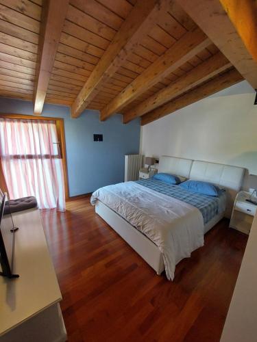 1 dormitorio con 1 cama grande y techo de madera en Les Maisons des Fleurs, en San Bartolomeo