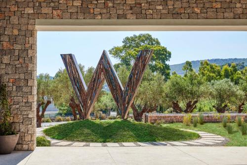 a large metal letter m in a garden at W Costa Navarino in Pylos