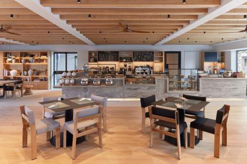 a dining room with tables and chairs and a kitchen at W Costa Navarino in Pylos