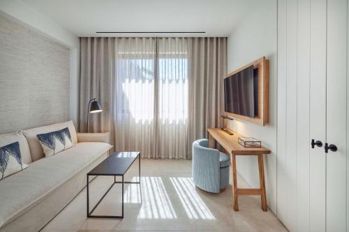 a living room with a couch and a table and a television at W Costa Navarino in Pylos