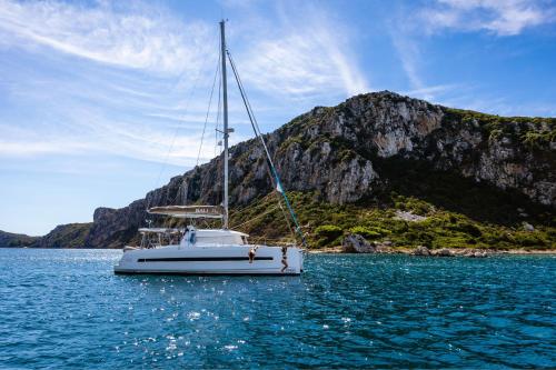 a white boat in the water with a mountain at W Costa Navarino in Pylos