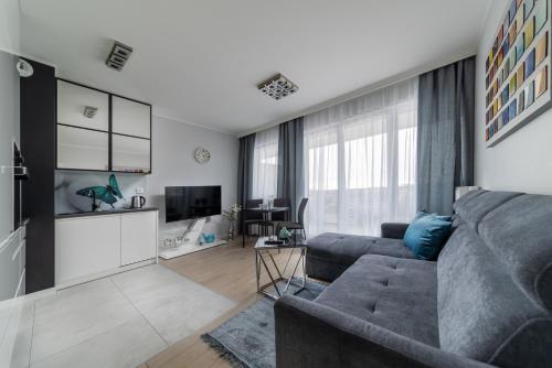 a living room with a couch and a tv at ResiNest Apartamenty Jagiellońskie J19 in Białystok