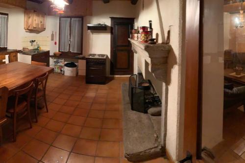 a kitchen with a fireplace in the middle of a room at Rustico Cà Laura in Brione