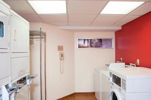 - un lave-linge dans une pièce dotée d'un mur rouge dans l'établissement TownePlace Suites by Marriott Indianapolis - Keystone, à Indianapolis