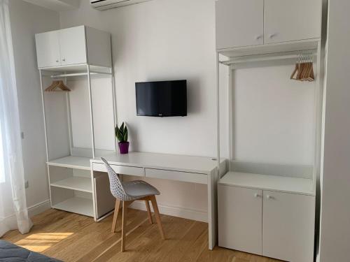 龐貝的住宿－Magister Guest House，一张带椅子的白色书桌和墙上的电视