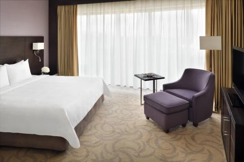 um quarto de hotel com uma cama e uma cadeira em Courtyard Riyadh by Marriott Diplomatic Quarter em Riyadh