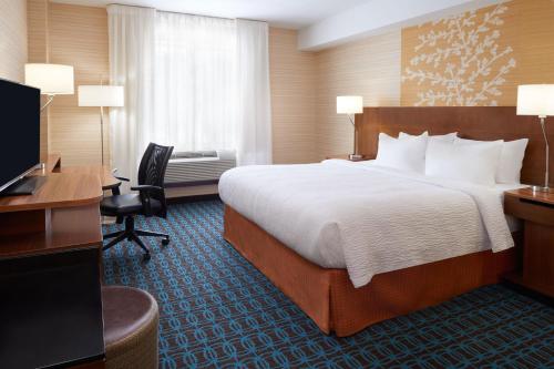 a hotel room with a large bed and a desk at Fairfield Inn & Suites by Marriott Barrie in Barrie