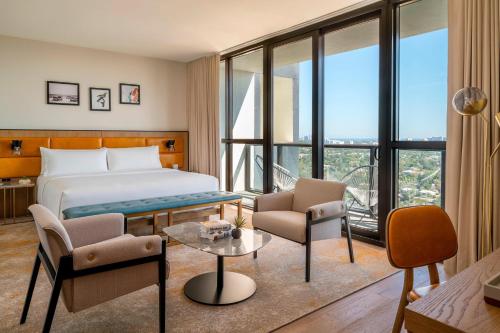 フォート・ローダーデールにあるThe Dalmar, Fort Lauderdale, a Tribute Portfolio Hotelのベッド、椅子、窓が備わるホテルルームです。