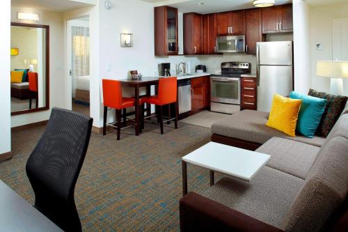 a living room with a couch and a kitchen at Residence Inn by Marriott Orlando Lake Nona in Orlando