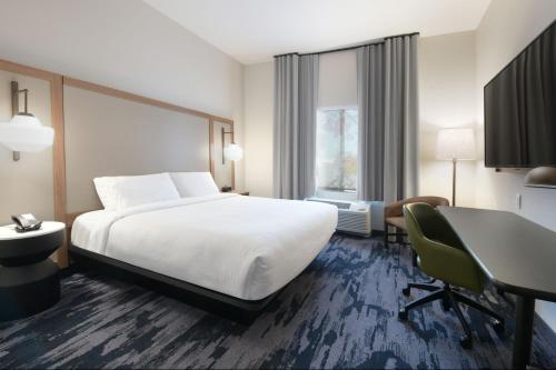 a hotel room with a bed and a desk at Fairfield by Marriott Inn & Suites Dallas East in Dallas