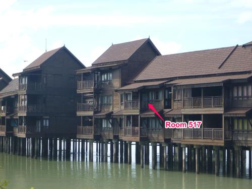 a row of houses on the water with a room sign at Langkawi Lagoon Hotel Resort in Kampung Padang Masirat