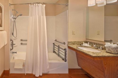 a bathroom with a shower and a tub and a sink at TownePlace Suites by Marriott Fort Lauderdale Weston in Weston