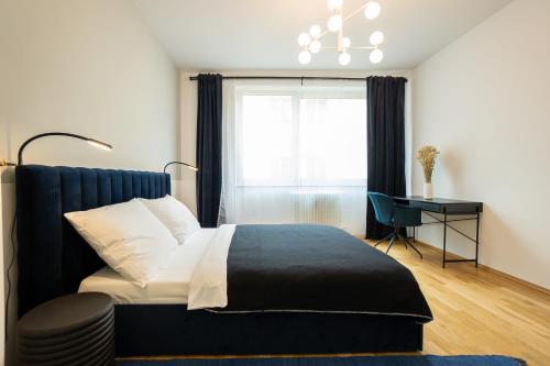 a bedroom with a bed and a window and a desk at Bright stylish apartment in a top location in Vienna