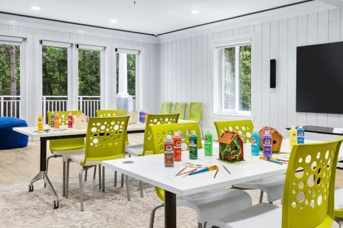 a dining room with white tables and yellow chairs at Marriott's SurfWatch in Hilton Head Island