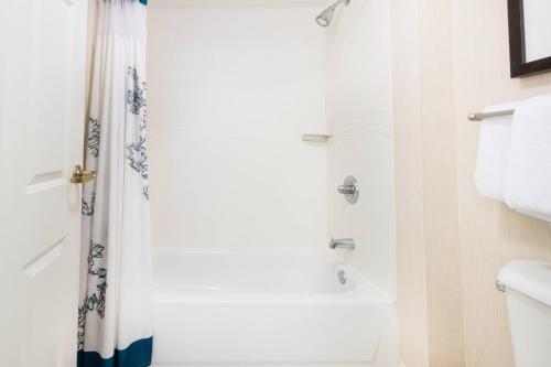 a white bathroom with a shower and a sink at Residence Inn by Marriott Evansville East in Evansville