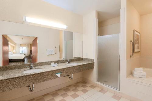 a hotel bathroom with two sinks and a shower at Fairfield Inn & Suites Temecula in Temecula