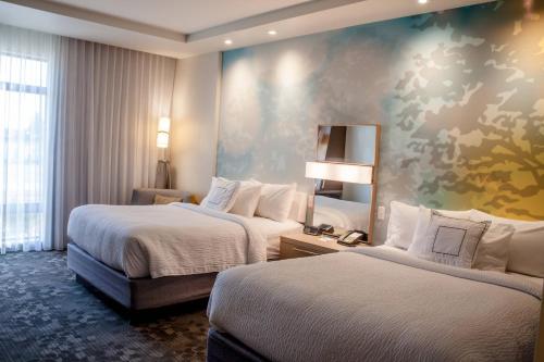um quarto de hotel com duas camas e uma parede em Courtyard by Marriott Omaha East/Council Bluffs, IA em Council Bluffs