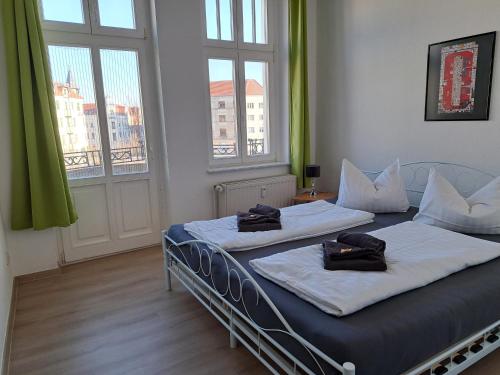 duas camas num quarto com duas janelas em Apartment-Hotel Schillerplatz em Wittenberge